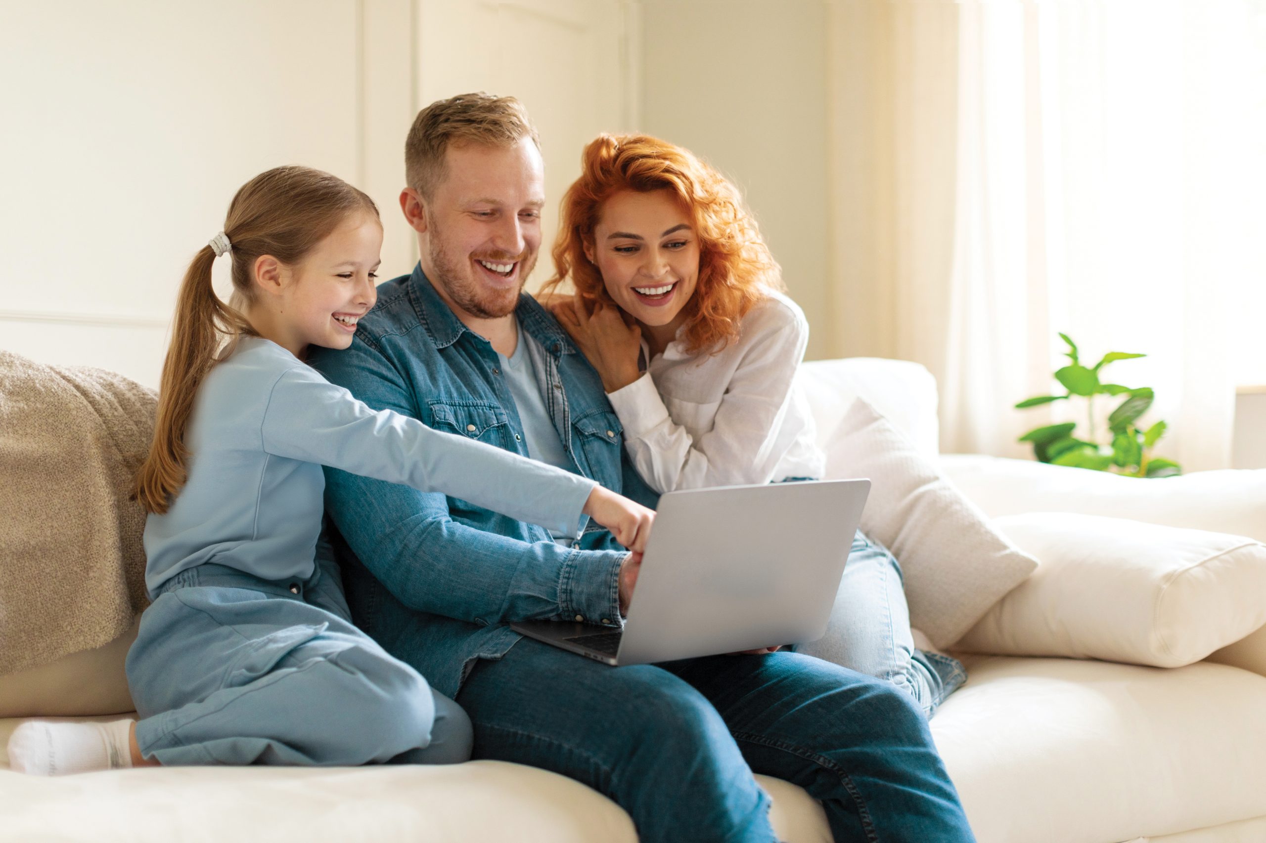 Family pointing to something on a laptop